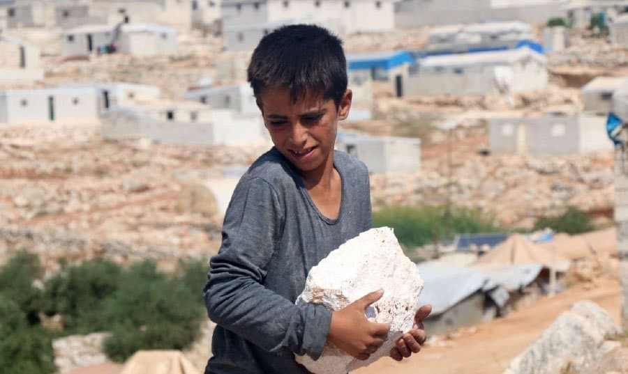 طفل سوري يكسّر الأحجار لإعالة...