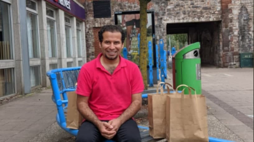 لاجئ سوري يوزع الطعام على المش...