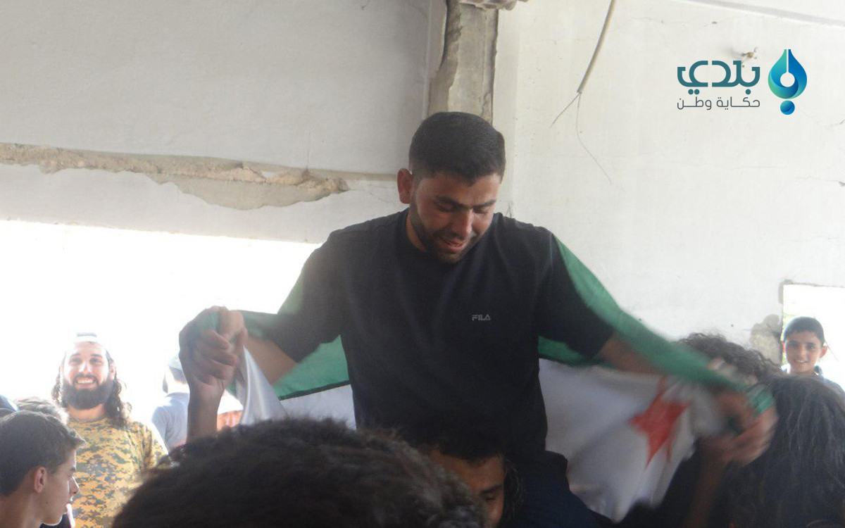 متشحاً بعلم الثورة.. شاب حمصي...